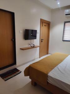 a bedroom with a bed and a flat screen tv at Hotel Bhaiji Executive in Nānded