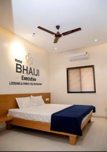 Schlafzimmer mit einem Bett und einem Deckenventilator in der Unterkunft Hotel Bhaiji Executive in Nanded-Waghala