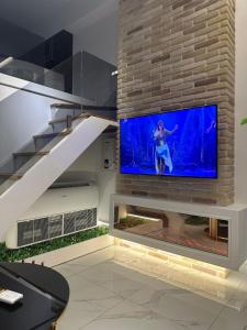 - un salon avec une grande télévision sur un mur en briques dans l'établissement Rent Room 4 Rolandi Apartments, à Pogradec
