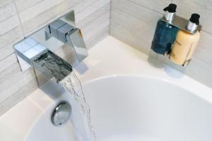 ein Waschbecken mit Wasser aus einem Wasserhahn in der Unterkunft Gwbert Holiday Cottages, Gwynt Y Mor in Cardigan + 11 Fotos