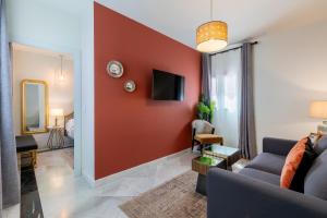 a living room with a red accent wall at Arco de la Seda - Hotel Boutique in Seville