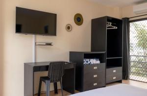1 dormitorio con escritorio y TV en la pared en Masayahin Cabanavillas, en Santander