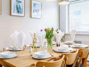 einen Esstisch mit Stühlen und eine Flasche Wein in der Unterkunft Gwbert Holiday Cottages, Gwynt Y Mor in Cardigan