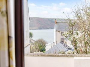ein Blick aus einem Fenster auf eine Kirche und Wasser in der Unterkunft Gwbert Holiday Cottages, Gwynt Y Mor in Cardigan