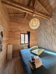 Le Chalet Cocon في لا بيتيت-بيير: غرفة نوم في كابينة خشب بها سرير