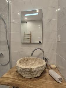 Le Chalet Cocon في لا بيتيت-بيير: حمام مع حوض حجري ومرآة
