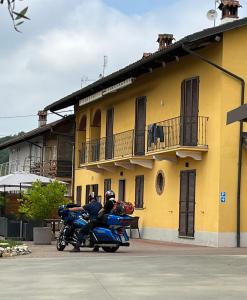 due persone in moto parcheggiate di fronte a un edificio giallo di certe notti langhe a Salmore