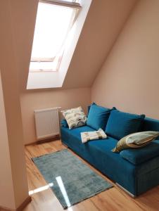 a blue couch in a room with a skylight at Apartament Gardena II Olsztyn Jaroty in Olsztyn