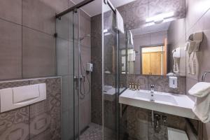 a bathroom with a sink and a shower at City Hotel Ring in Budapest