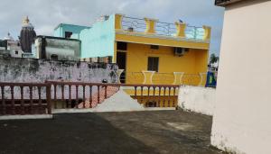 - un bâtiment jaune avec un balcon au-dessus dans l'établissement Divine view - 1 bhk AC - Swarna Bhavan, à Purî