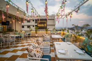 RABBIT RATNAM -By Udaipur Hotels في أودايبور: مطعم به طاولات وكراسي واضاءات