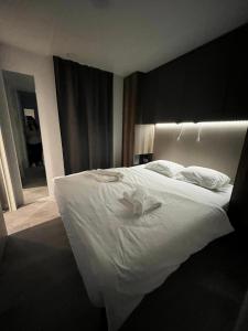 um quarto com uma grande cama branca com lençóis brancos em Mobilna hiška Hupi em Velenje