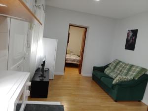 uma sala de estar com um sofá verde e um quarto em Home P.C em Getafe