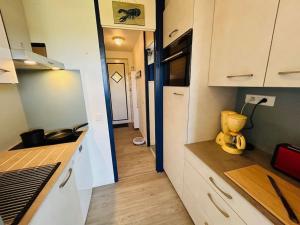 eine Küche mit weißen Schränken und einem gelben Gerät auf der Theke in der Unterkunft "LE GREEN" Appartement, 4 personnes, accès piscines gratuit in Talmont