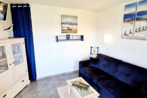 ein Wohnzimmer mit einem Sofa und einem Tisch in der Unterkunft "LE GREEN" Appartement, 4 personnes, accès piscines gratuit in Talmont