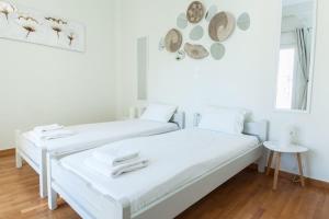 two beds in a white room with hats on the wall at Shades of Athens in Athens