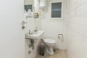 a white bathroom with a toilet and a sink at Shades of Athens in Athens