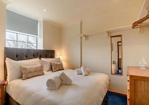 a bedroom with a large white bed with towels on it at Orchard Retreat in Docking