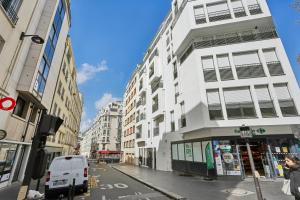 a white building on a city street with a white van at Chic et minimaliste studio Batignolle/Montmartre by Weekome in Paris