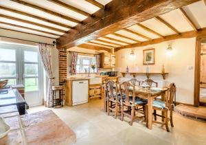 uma cozinha e sala de jantar com mesa e cadeiras em Orchard Cottage em East Dereham