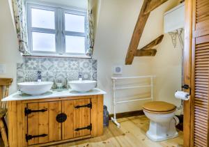 a bathroom with two sinks and a toilet at Orchard Cottage in East Dereham