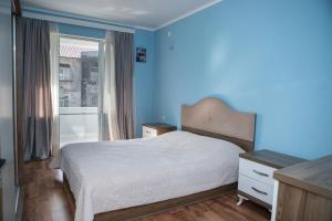 a bedroom with a white bed and a blue wall at Chakvi Lux House in Chakvi
