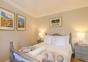 a bedroom with a bed with white sheets and pillows at 2 Oaklands Cottage in Holt