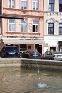 a water fountain in front of a building with cars at Penzion Pod Kašnou in Frýdek-Místek