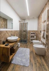 ein Badezimmer mit 2 Waschbecken, einer Dusche und 2 WCs in der Unterkunft certe notti langhe in Salmore