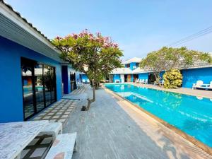 una piscina con un árbol al lado de un edificio en Fisherman Resort at Sam Roi Yot, en Baanphakrimlay 