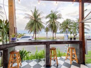 un bar con 2 taburetes y vistas a la playa en Fisherman Resort at Sam Roi Yot, en Baanphakrimlay 