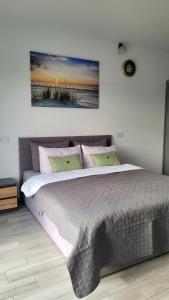 um quarto com uma cama grande e 2 almofadas em Hotelik Neptun em Ustronie Morskie