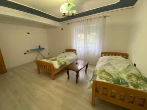 1 Schlafzimmer mit 2 Betten und einem Fenster in der Unterkunft Apartament me qera 2+1 in Kukës