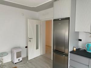 a kitchen with a refrigerator and a table in it at Apartament me qera 2+1 in Kukës