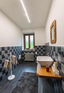 ein Badezimmer mit einem Waschbecken und einer Badewanne in der Unterkunft certe notti langhe in Salmore