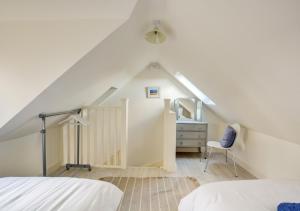 een slaapkamer met een bed, een bureau en een stoel bij Marsh View in Salthouse
