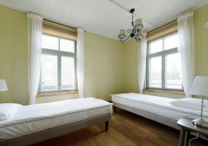 two beds in a room with two windows at Tiigi Apartment in Paide