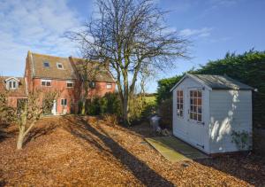 een kleine witte schuur voor een huis bij Marsh View in Salthouse