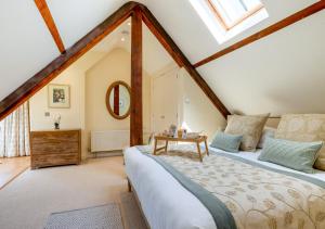 1 dormitorio en el ático con 1 cama y 1 mesa en Boat Barn Cottage, en Blakeney
