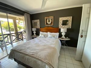a bedroom with a large bed and a balcony at 10 Summerplace in Knysna
