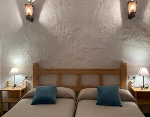 um quarto com duas camas e duas luzes na parede em Casa Rural María Y Cristina em Alhama de Múrcia
