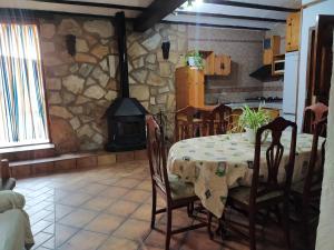 uma sala de jantar com uma mesa e uma lareira de pedra em Casa Rural María Y Cristina em Alhama de Múrcia