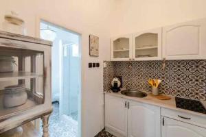 a kitchen with a sink and a glass door at Angel apartman in Bratislava +6 photos