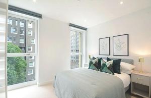 a white bedroom with a bed and a large window at Luxury Collection - London Bridge in London