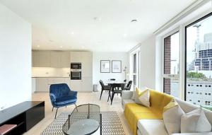 a living room with a yellow couch and a kitchen at Luxury Collection - London Bridge in London