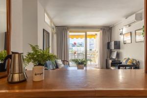 a kitchen with a table and a living room at Apartamentos Novelty Arysal in Salou