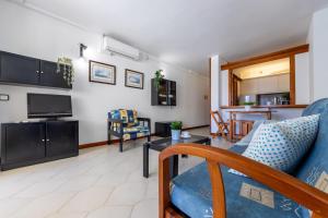 a living room with a couch and a tv at Apartamentos Novelty Arysal in Salou