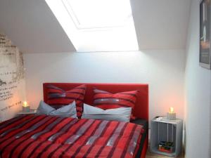1 dormitorio con 1 cama roja con almohadas y 2 velas en Lust 3 in Malchow en Malchow