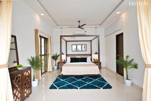 a bedroom with a bed and a blue rug at EKOSTAY Luxe - Oceanic Villa in Alibaug