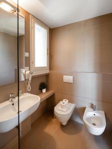 baño con lavabo y aseo y ventana en Residence Poggio Golf Chianti Firenze, en Impruneta